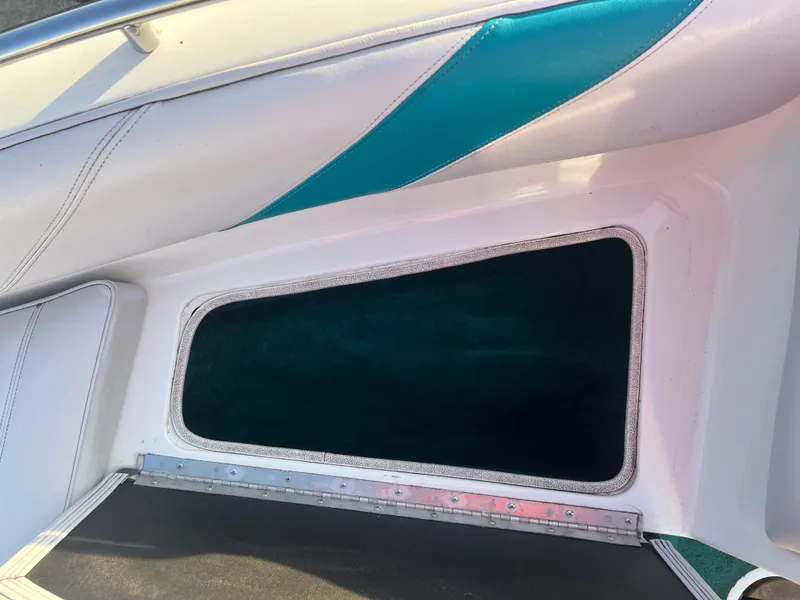 Slide: The Image of Interior view of a 1992 Celebrity 180 Bowrider boat with teal and white upholstery. - 10