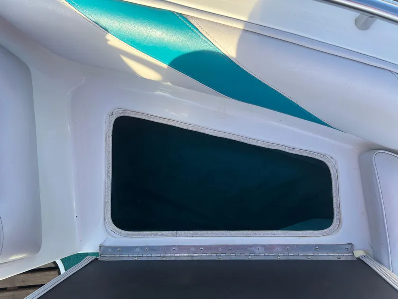 Slide: The Image of Interior view of a 1992 Celebrity 180 Bowrider boat with teal accents. - 11