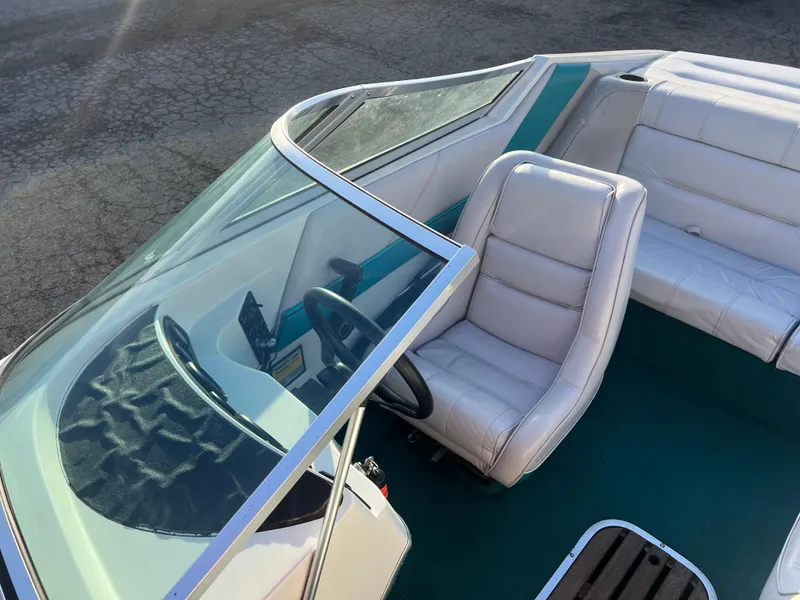 Slide: The Image of 1992 Celebrity 180 Bowrider boat interior with white seats and steering wheel. - 12