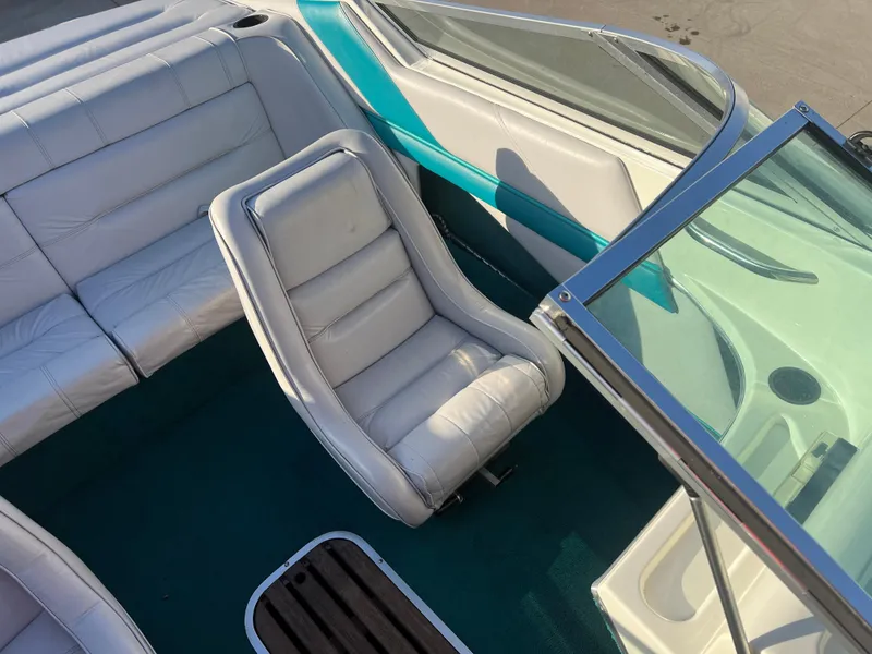 Slide: The Image of Interior of 1992 Celebrity 180 Bowrider boat with white seating and teal accents. - 13