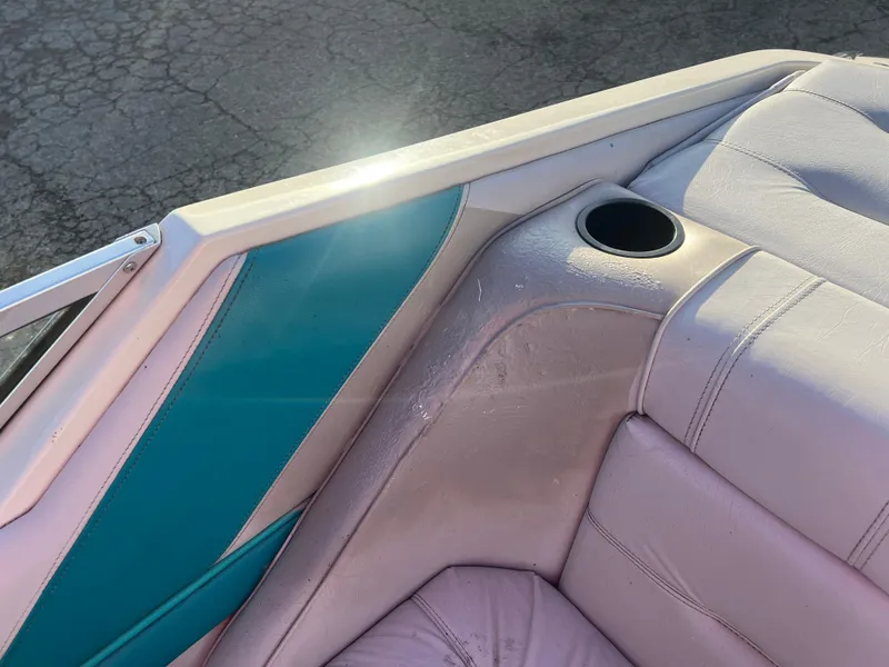 Slide: The Image of Interior of a 1992 Celebrity 180 Bowrider boat with teal and white upholstery. - 18