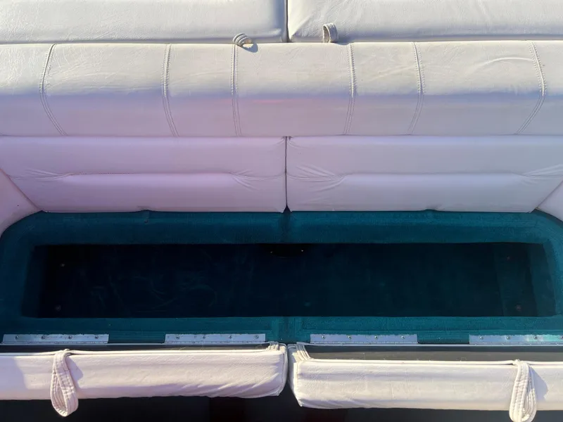 Slide: The Image of 1992 Celebrity 180 Bowrider boat seating with storage compartment open. - 19