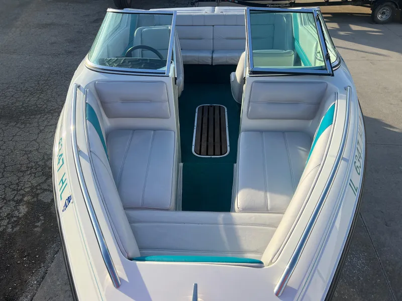 Slide: The Image of 1992 Celebrity 180 Bowrider boat with white and teal interior, open seating layout. - 8