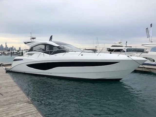 Slide: The Image of 2018 Galeon 485 yacht docked at marina, sleek white design, calm water. - 1
