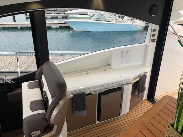 Slide: The Image of Interior view of 2018 Galeon 485 yacht with seating and kitchenette by the water. - 10