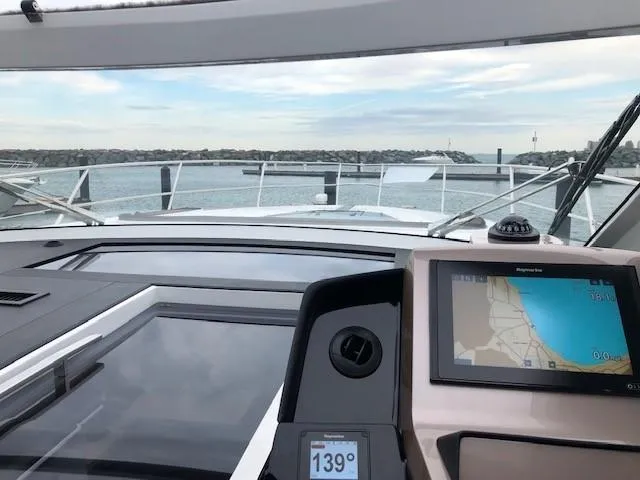 Slide: The Image of Galeon 485 yacht cockpit view with navigation display, 2018 model, overlooking calm waters. - 12