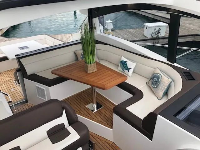 Slide: The Image of Luxurious seating area on 2018 Galeon 485 yacht with elegant cushions and wooden table. - 14