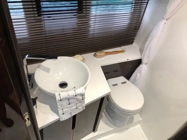 Slide: The Image of Modern bathroom in 2018 Galeon 485 yacht with sink, toilet, and window blinds. - 33