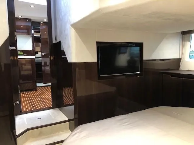 Slide: The Image of Interior of 2018 Galeon 485 yacht, featuring a cozy bedroom with a mounted TV. - 42