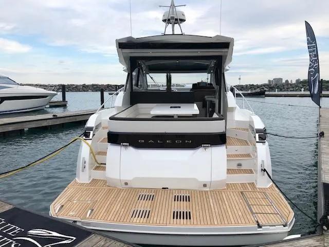Slide: The Image of 2018 Galeon 485 yacht docked, showcasing sleek design and spacious deck. - 6