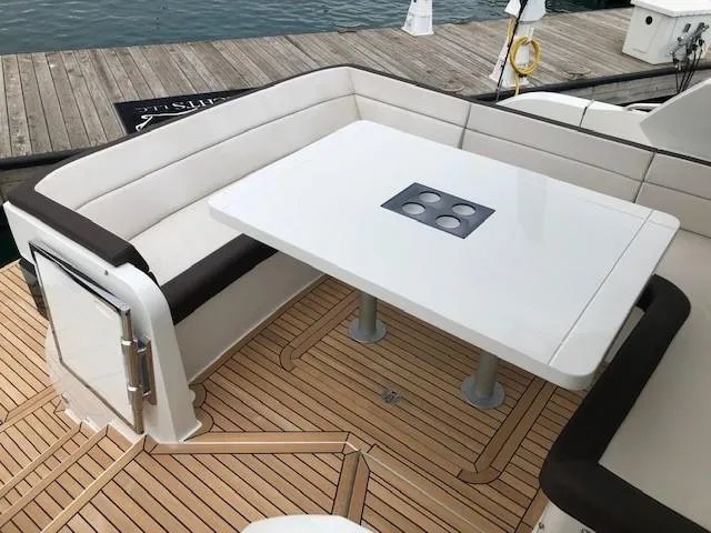 Slide: The Image of Luxury seating area on 2018 Galeon 485 yacht with white table and cushioned benches. - 8
