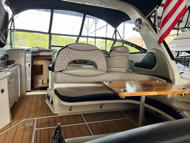 Slide: The Image of 2002 Sea Ray 380 Sundancer interior with elegant seating and wooden table. - 23