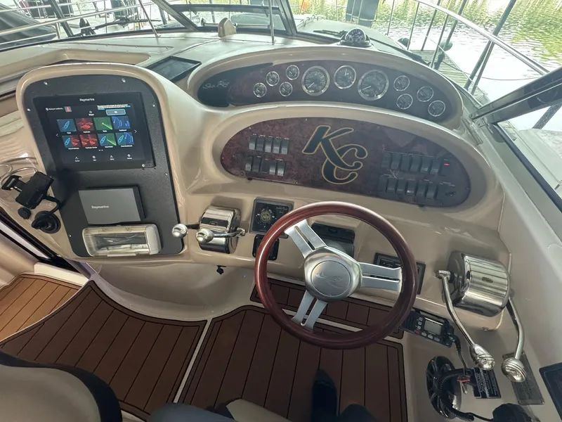 Slide: The Image of 2002 Sea Ray 380 Sundancer helm with wood accents and modern controls. - 29