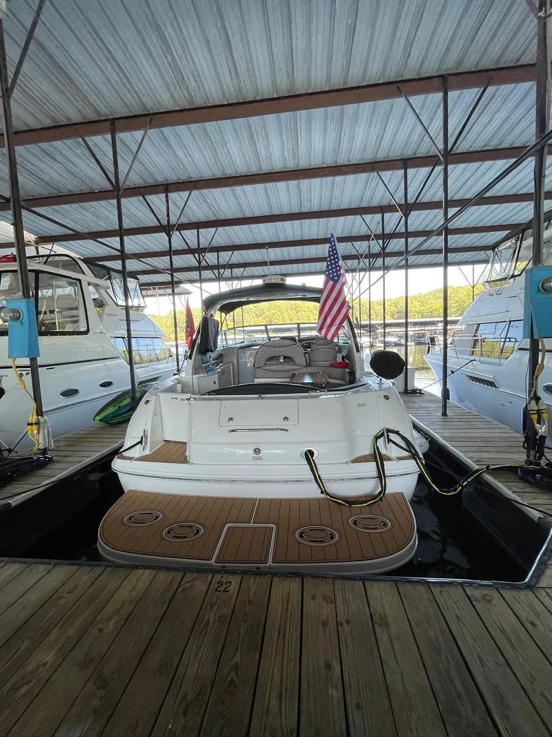 Slide: The Image of 2002 Sea Ray 380 Sundancer docked under a covered marina with American flag. - 3