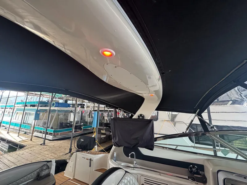 Slide: The Image of 2002 Sea Ray 380 Sundancer interior with black canopy and docked boats in background. - 31