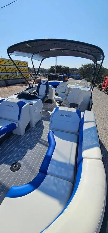 Slide: The Image of 2022 Berkshire 25E STS pontoon boat with blue and white seating, under a sunny sky. - 10
