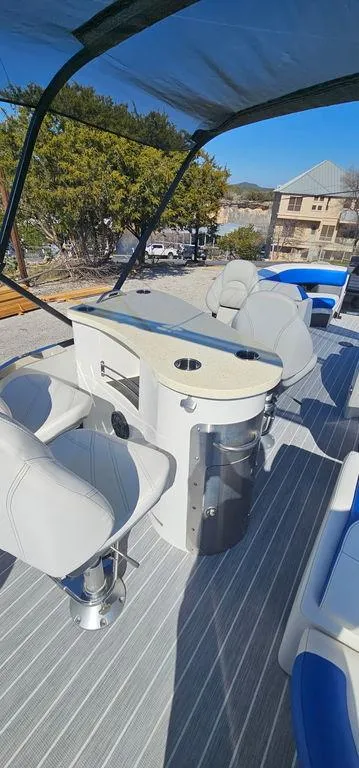 Slide: The Image of 2022 Berkshire 25E STS pontoon boat interior with seating and table under canopy. - 14