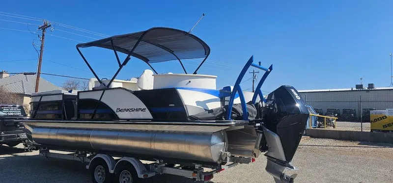 Slide: The Image of 2022 Berkshire 25E STS pontoon boat on trailer, featuring a sleek design and powerful outboard motor. - 2