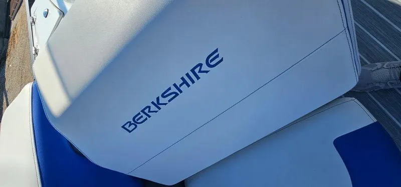 Slide: The Image of 2022 Berkshire 25E STS boat seat with logo, featuring blue and white upholstery. - 22