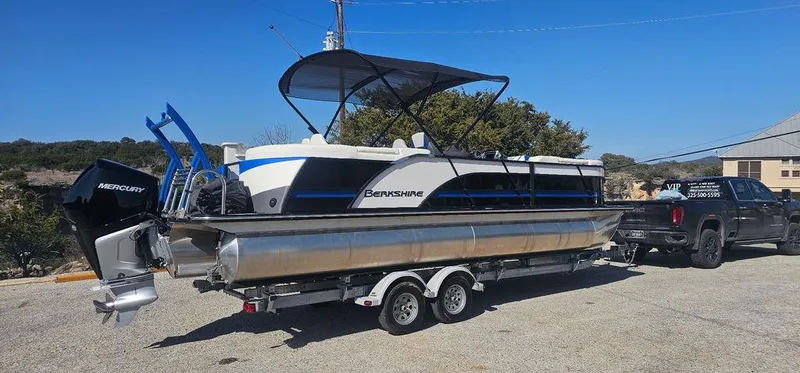 Slide: The Image of 2022 Berkshire 25E STS pontoon boat on trailer, hitched to a black truck. - 3