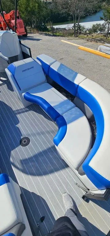 Slide: The Image of 2022 Berkshire 25E STS boat interior with blue and white seating on a sunny day. - 6