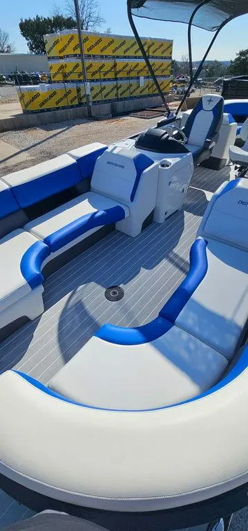 Slide: The Image of 2022 Berkshire 25E STS pontoon boat with blue and white seating, docked outdoors. - 7