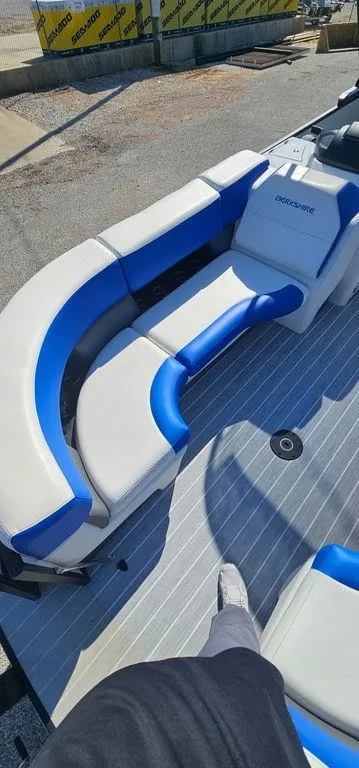 Slide: The Image of 2022 Berkshire 25E STS boat with blue and white seating on a sunny day. - 8