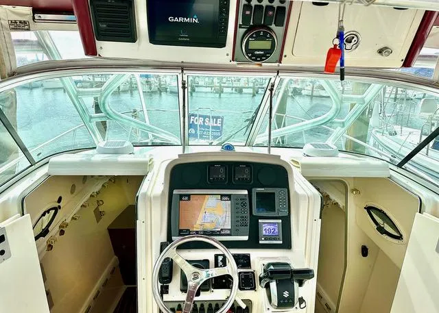Slide: The Image of 2009 World Cat 290 EC boat cockpit with Garmin navigation system, steering wheel, and control panel. - 12