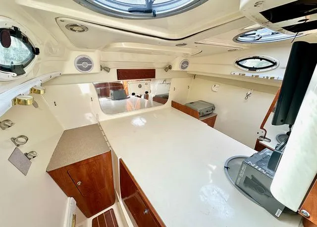 Slide: The Image of 2009 World Cat 290 EC cabin interior with white surfaces and wood accents. - 13