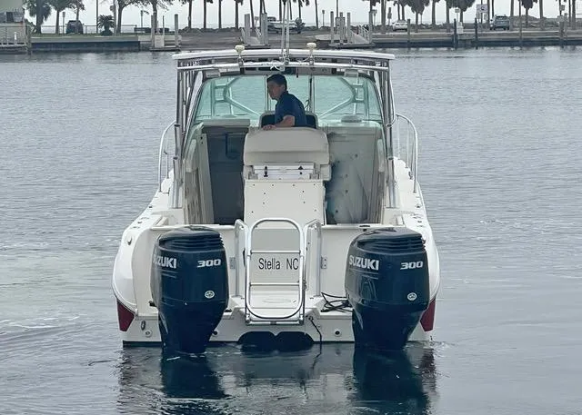 Slide: The Image of 2009 World Cat 290 EC boat with dual Suzuki 300 engines on calm water. - 2