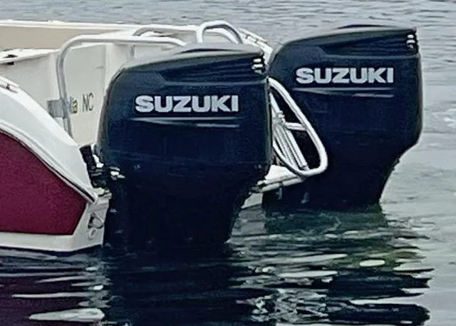 Slide: The Image of Twin Suzuki outboard motors on a 2009 World Cat 290 EC boat in water. - 3