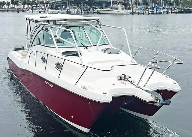 Slide: The Image of 2009 World Cat 290 EC boat with red hull, docked in marina. - 4