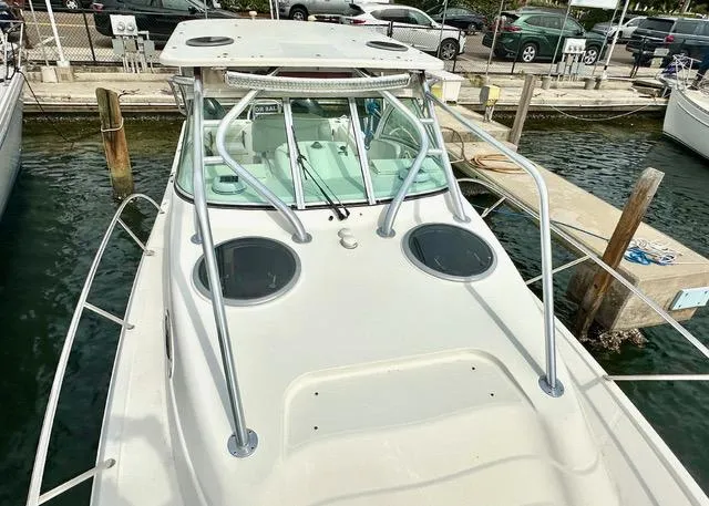 Slide: The Image of 2009 World Cat 290 EC boat docked at marina, featuring spacious deck and sturdy railings. - 7
