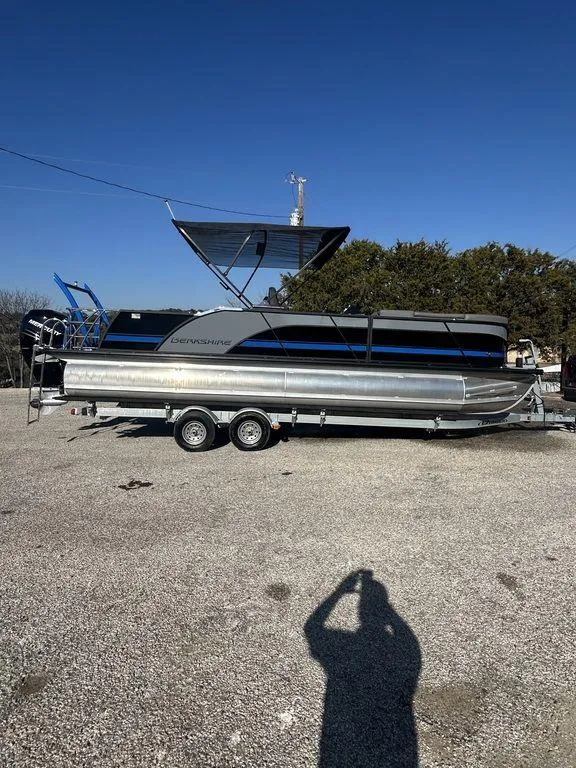 The Image of 2023 Berkshire 25UL STS 3.0 pontoon boat on trailer, parked outdoors. - 1