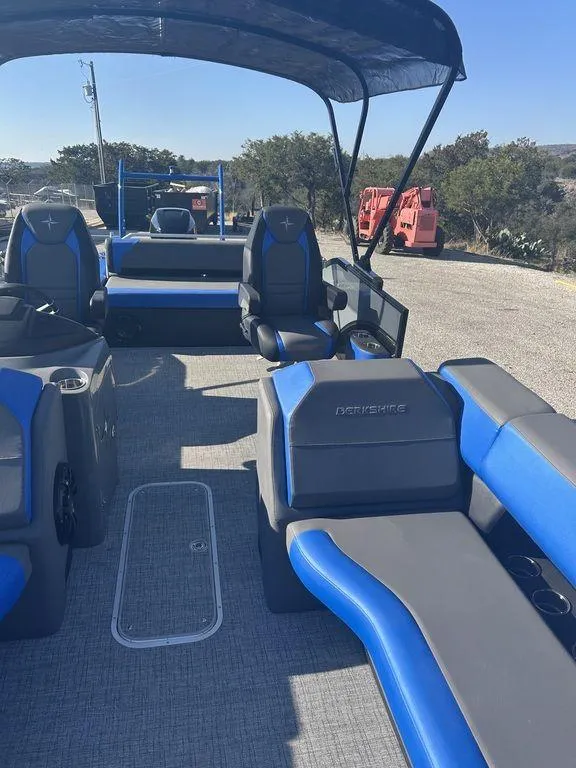 Slide: The Image of 2023 Berkshire 25UL STS 3.0 pontoon boat with blue and gray seating, outdoor setting. - 18