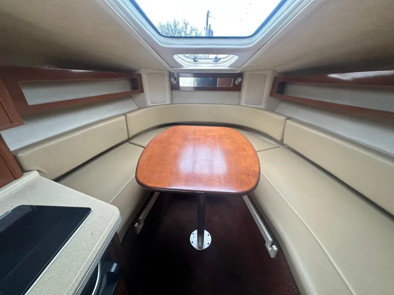 Slide: The Image of Interior of 2012 Sea Ray 280 Sundancer with cozy seating and wooden table. - 14