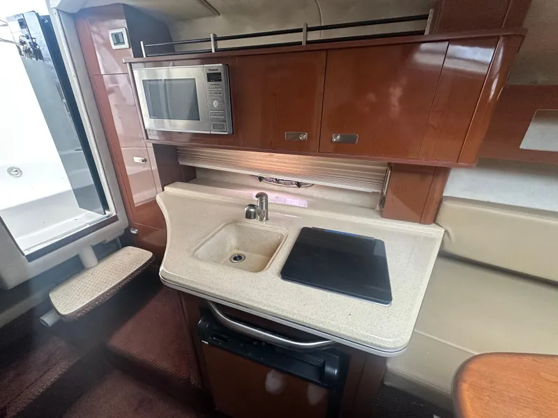 Slide: The Image of Interior of 2012 Sea Ray 280 Sundancer with kitchenette, sink, and microwave. - 16