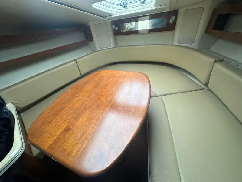 Slide: The Image of Interior cabin of 2012 Sea Ray 280 Sundancer with beige seating and wooden table. - 20