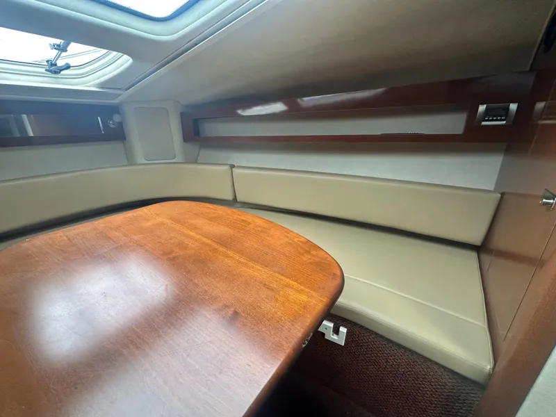 Slide: The Image of Interior of 2012 Sea Ray 280 Sundancer with wooden table and beige seating. - 21
