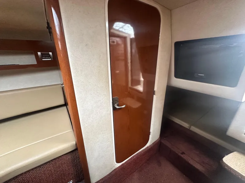 Slide: The Image of Interior cabin of 2012 Sea Ray 280 Sundancer with seating and wooden door. - 22