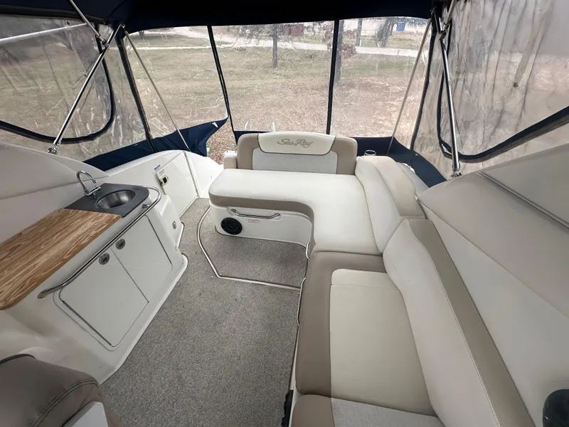 Slide: The Image of 2012 Sea Ray 280 Sundancer interior with beige seating and kitchenette. - 7