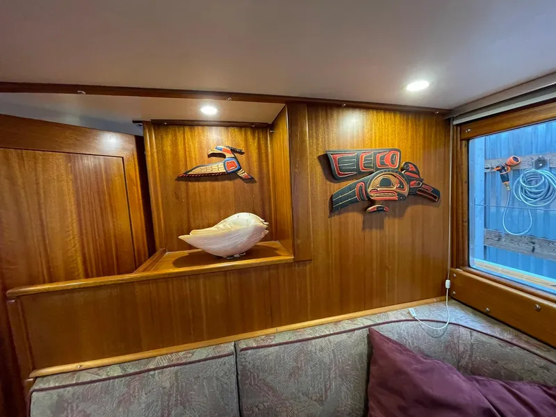 Slide: The Image of 1959 Monk Express Cruiser interior with wooden paneling, decorative carvings, and a cozy seating area. - 11