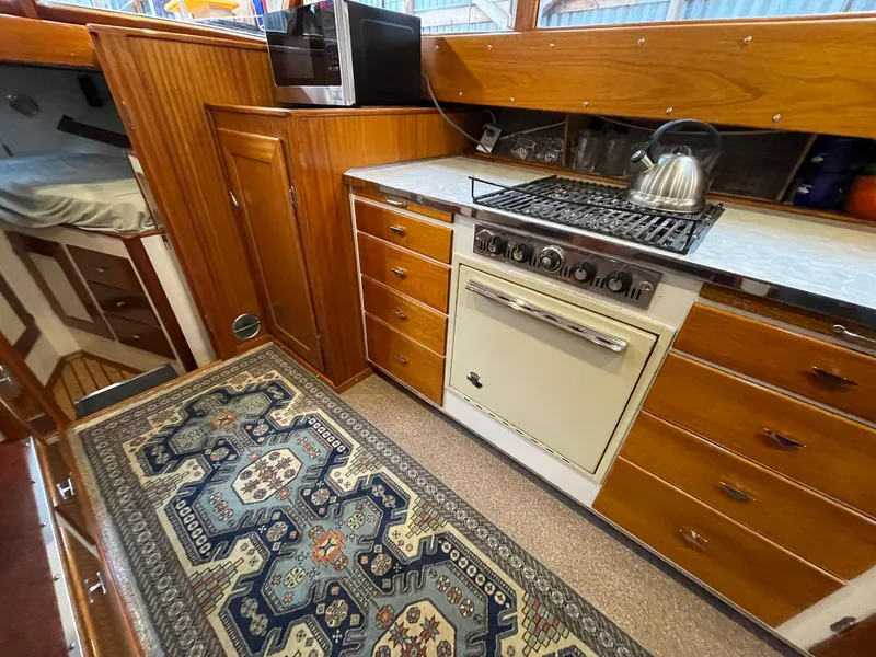 Slide: The Image of Vintage 1959 Monk Express Cruiser kitchen with wooden cabinets and a patterned rug. - 17