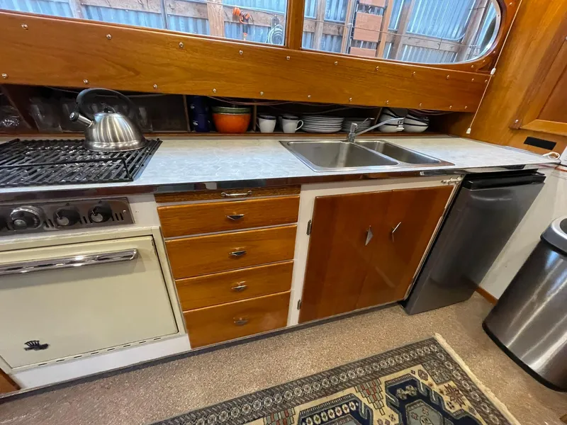 Slide: The Image of 1959 Monk Express Cruiser kitchen with stove, sink, and wooden cabinetry. - 18