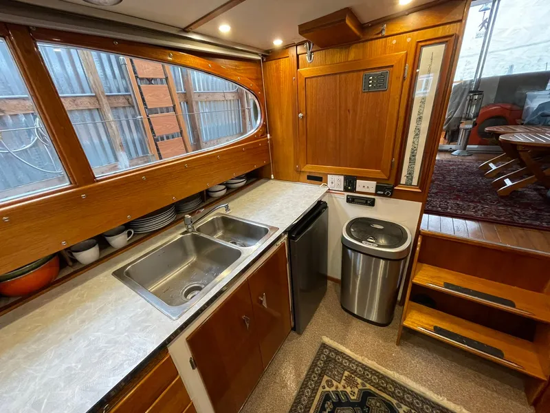 Slide: The Image of 1959 Monk Express Cruiser kitchen with wooden cabinetry, stainless steel sink, and compact appliances. - 19