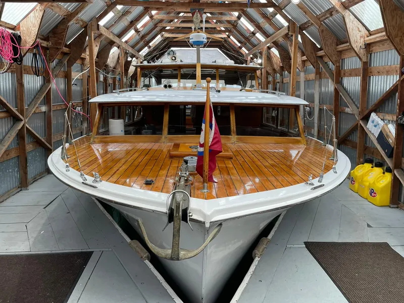 Slide: The Image of 1959 Monk Express Cruiser in a wooden boathouse, showcasing polished deck and classic design. - 2