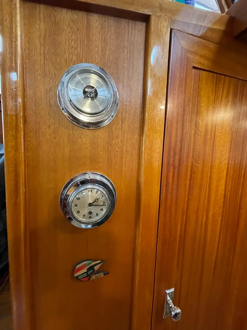 Slide: The Image of 1959 Monk Express Cruiser interior with wooden paneling, clock, and barometer. - 21
