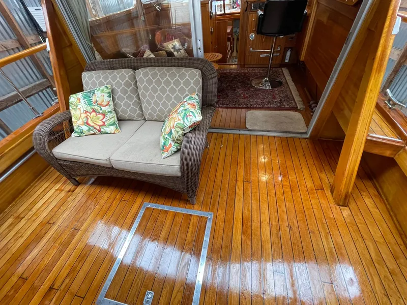 Slide: The Image of 1959 Monk Express Cruiser interior with polished wood floor, wicker sofa, and floral cushions. - 32