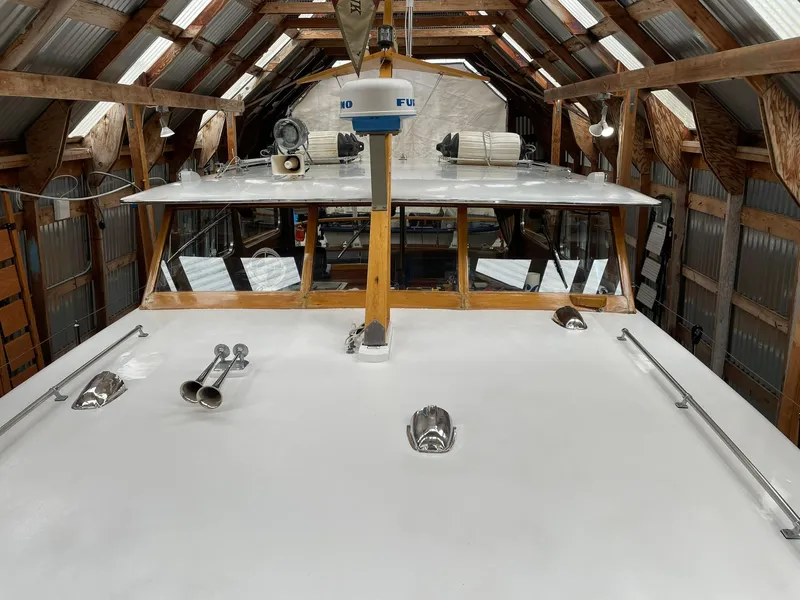 Slide: The Image of 1959 Monk Express Cruiser in a wooden boathouse, showcasing its deck and equipment. - 7