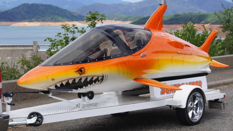 Slide: The Image of Futuristic 2025 Seabreacher X, Y, Z shark-shaped watercraft on trailer by scenic lake. - 17